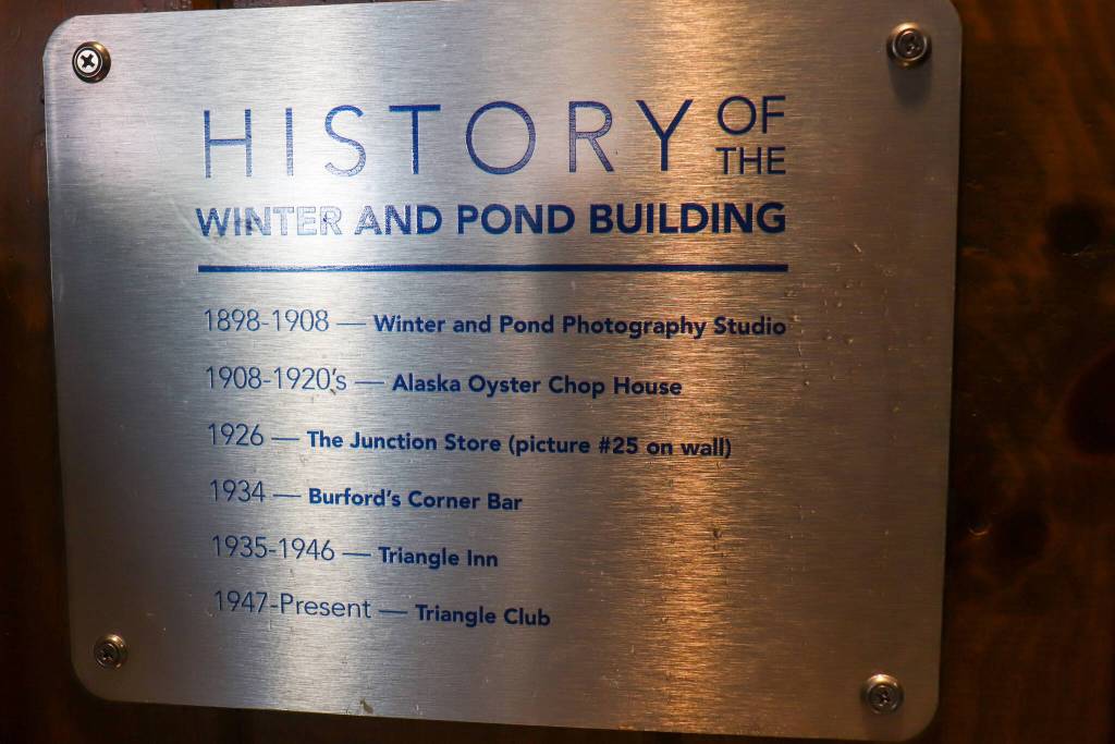 A plaque inside the Triangle Club shows the history of ownership. (Jasz Garrett / Juneau Empire)