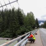 Jonathan Tuttle, a hydrologist with the U.S. Geological Survey, installs monitoring equipment at the Mendenhall River bridge on Back Loop Road Thursday morning. (Jasz Garrett / Juneau Empire)