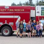 Retired Capital City Fire/Rescue Assistant Chief Ed Quinto takes a photo with his family at the Hagevig Regional Fire Training Center on Saturday. (Jasz Garrett / Juneau Empire)