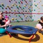 Jennifer Parkin and Rose McLean play with their babies in an area reserved for young children at Capitol Park on Saturday. (Jasz Garrett / Juneau Empire)
