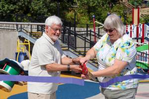 Mayor Beth Weldon cuts a ribbon for Capitol Parks opening Saturday with John Pugh, Juneau Park Foundation vice chair and Juneau Community Foundation board president. (Jasz Garrett / Juneau Empire)