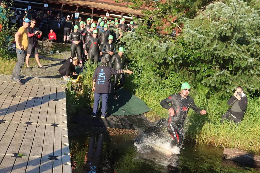 Competitors in the Aukeman Triathlons long course begin their 1,900-meter swim in Auke Lake on Sunday morning at the University of Alaska Southeast campus. (Mark Sabbatini / Juneau Empire)
