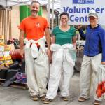 From left to right: Jeff Smith, Tanna Peters and Gwenna Corvez return for food after finishing pulling insulation out of two crawlspaces in a row on Saturday morning. (Jasz Garrett / Juneau Empire)