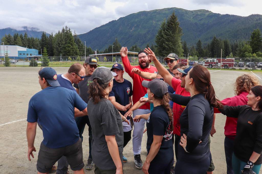 Capital City Fire/Rescues softball team celebrates after their win against the Juneau Police Department and Alaska State Troopers. (Jasz Garrett / Juneau Empire)