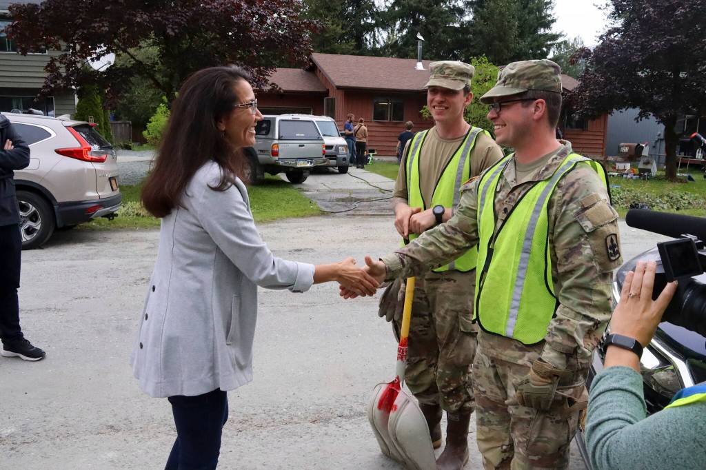U.S. Rep. Mary Peltola on Sunday greets Alaska Organized Militia members Jacob Miller and Robert Brian, two of the seven Juneau AKOM members and 60 statewide that are assisting with flood recovery efforts. (Mark Sabbatini / Juneau Empire)