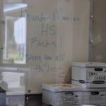 Boxes labeled Thunder Mountain Middle School office wait to be unpacked underneath a whiteboard inside TMMS on Monday. (Jasz Garrett / Juneau Empire)