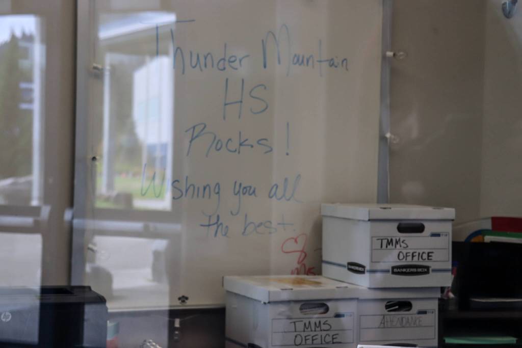 Boxes labeled Thunder Mountain Middle School office wait to be unpacked underneath a whiteboard inside TMMS on Monday. (Jasz Garrett / Juneau Empire)