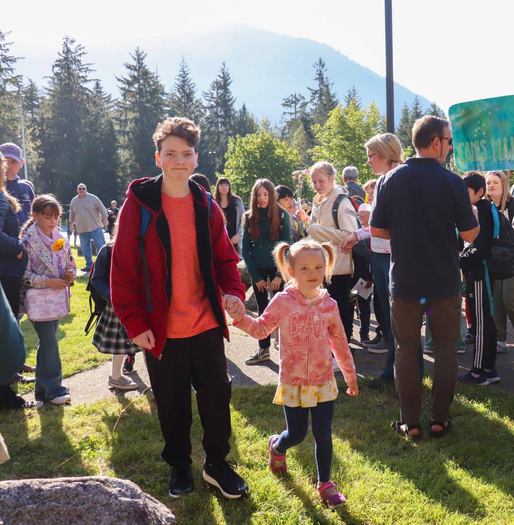 Chase Van Linden and Eliana Porter, the oldest and youngest student, start the first day of school for Montessori Borealis Public Alternative School on Thursday morning by being the first two to walk through the doors. (Jasz Garrett / Juneau Empire)