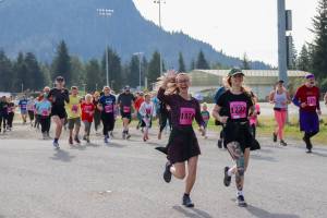 Ashley Murphy and Arianna Workman run toward the Kax̱dig̱oowu Héen Dei Trail in Cancer Connections 33rd annual Beat the Odds: A Race Against Cancer on Saturday. (Jasz Garrett / Juneau Empire)
