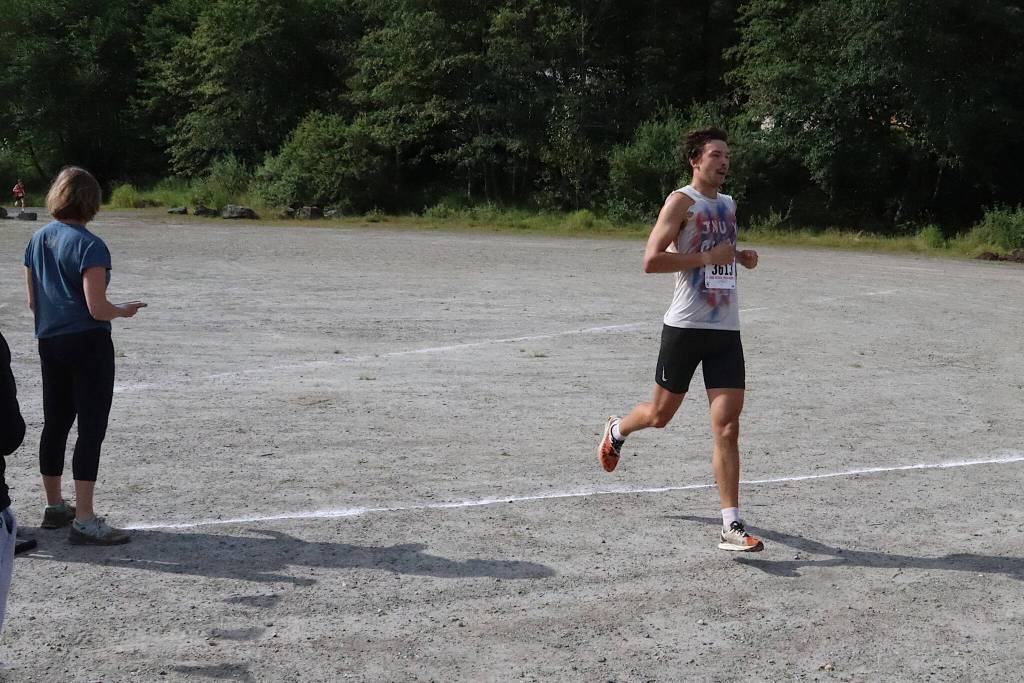 Zack Bursell, a coach of the cross-country team at Juneau-Douglas High School: Yadaa.at Kalé, is first across the finish line of the mens 5K race during the Sayéik Invitational at Savikko Park on Saturday morning. (Mark Sabbatini / Juneau Empire)