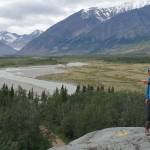 Phillip Wilson (blue jacket) and Dan Mann stand on a rock outcrop that was scoured by floodwaters a few centuries ago when Black Rapids Glacier  far in the distance  advanced to dam the Delta River. (Photo by Ned Rozell)