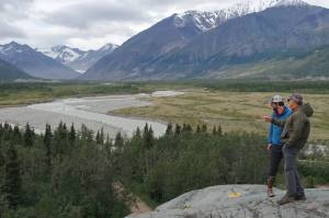 Phillip Wilson (blue jacket) and Dan Mann stand on a rock outcrop that was scoured by floodwaters a few centuries ago when Black Rapids Glacier  far in the distance  advanced to dam the Delta River. (Photo by Ned Rozell)