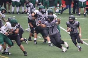 Juneau-Douglas High School: Yadaa.at Kalé linemen Ricky Tupou, (77), Jonah Mahle (54), Walter Haube-Law (55) and Benny Zukas (58) block for Ethan Van Kirk (3) during Saturdays game against Service High School at Adair-Kennedy Memorial Park. (Mark Sabbatini / Juneau Empire)