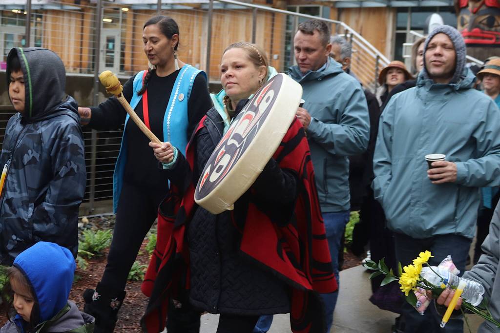 Dawn Kissack plays a Tlingit drum during a march for her brother, Steven, at a memorial gathering for him Sunday in downtown Juneau. (Mark Sabbatini / Juneau Empire)
