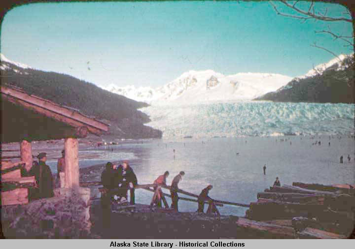 Skaters walk down steps to Mendenhall Lake. A rifle range built by the Civilian Conservation Corps is in the distance to the left. (ASL-P421-383)