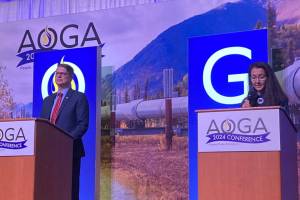 Republican challenger Nick Begich III and Democratic U.S. Rep. Mary Peltola are on the stage at the beginning of the Alaska Oil and Gas Associations candidate forum on Aug. 28, 2024. (Andrew Kitchenman/Alaska Beacon)