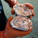A production manager checking for proper freezing holds a salmon he broke in half, at Circle Seafoods in Metlakatla on Aug. 19, 2024. Over the last few years, the $6 billion Alaskan wild seafood market has been ensnared in a mix of geopolitics, macroeconomics, changing ocean temperatures and post-Covid whiplash that piled on top of long-building vulnerabilities in the business model. (Ash Adams/The New York Times)