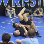 Weston and Wilder Wichman, brothers who are professional wresting instructors, demonstrate a move for students during a Juneau Youth Wrestling Club camp July 28. (Mark Sabbatini / Juneau Empire)