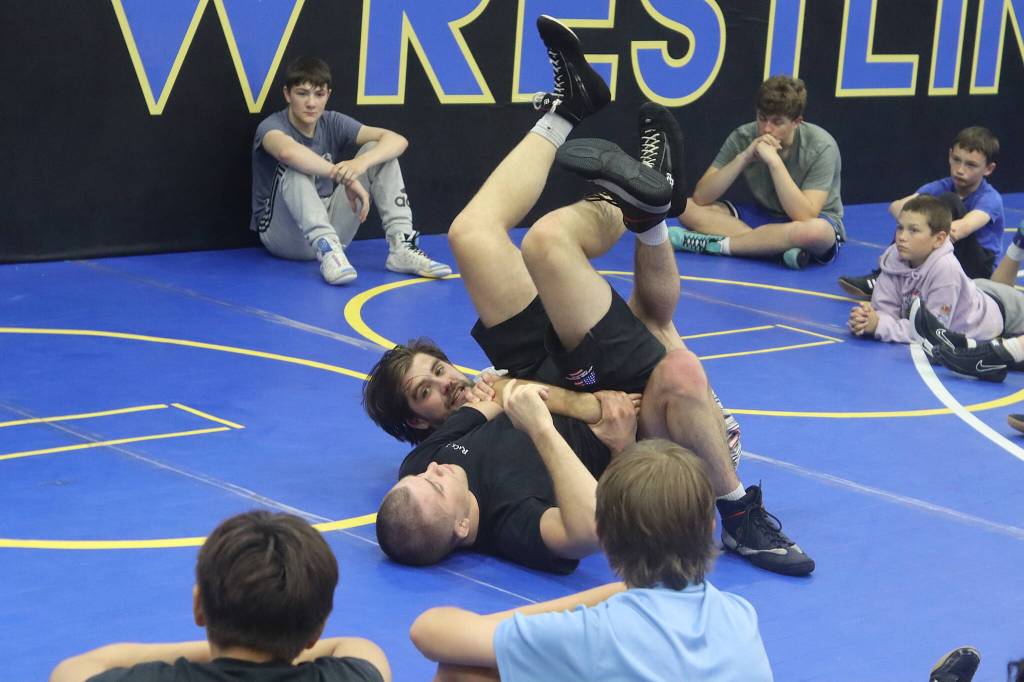 Weston and Wilder Wichman, brothers who are professional wresting instructors, demonstrate a move for students during a Juneau Youth Wrestling Club camp July 28. (Mark Sabbatini / Juneau Empire)