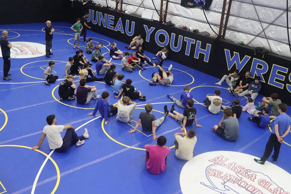 Students from Juneau and other Southeast Alaska communities watch a technique being demonstrated by professional wresting instructors Weston and Wilder Wichman during a Juneau Youth Wrestling Club camp July 28. (Mark Sabbatini / Juneau Empire)