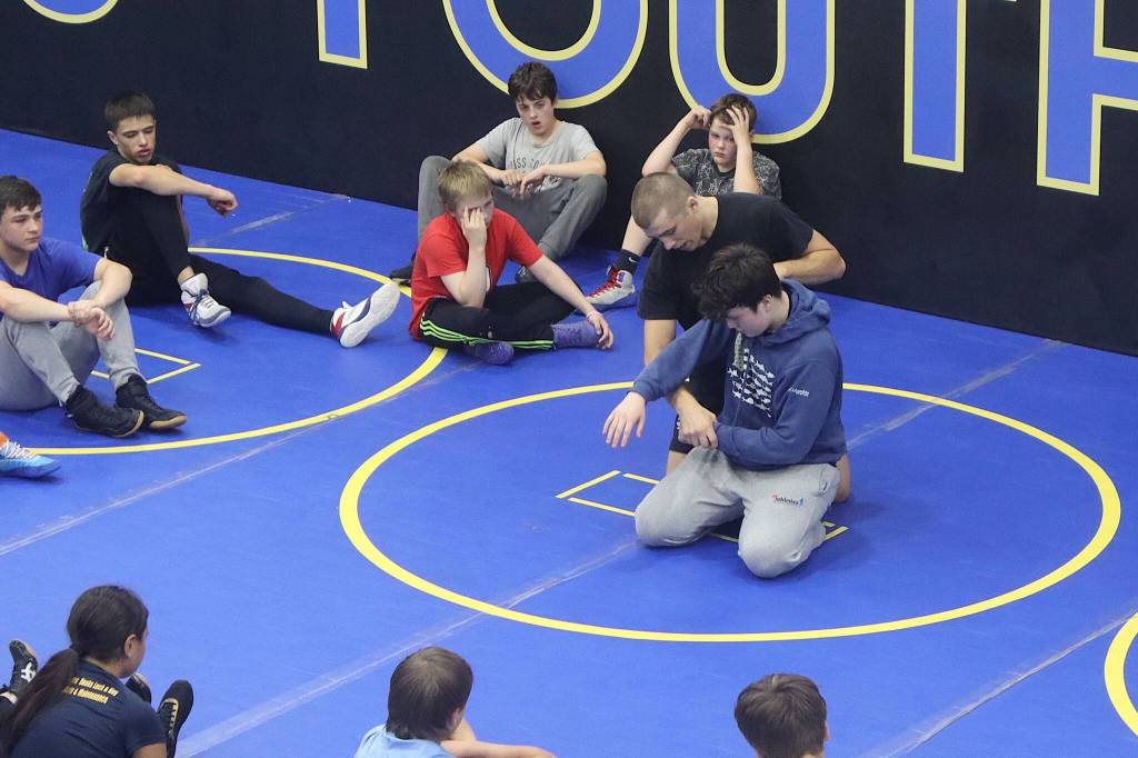 Wrestling coach Weston Wichman shows William Dapcevich, a Juneau high school wrestler, a technique during a July 28 camp at the Juneau Wrestling Center. (Mark Sabbatini / Juneau Empire)
