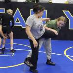 Abby Dolan (wearing green) tries to take down Sofia Contreras during a Juneau Youth Wrestling Club camp Sept. 1 at the Juneau Wrestling Center. (Mark Sabbatini / Juneau Empire)