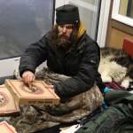 Steven Kissack and his dog, Juno, take shelter in the doorway of the Front Street Clinic building on Dec. 24, 2023. (Mark Sabbatini / Juneau Empire file photo)