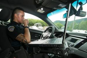 City and Borough of Juneau photo
A Juneau Police Department officer talks on a radio in a patrol car. Officials said JPDs communications system, which had an end-of-life date in 2014, needs to be replaced to provide improvements such as full radio coverage within the city and borough limits.