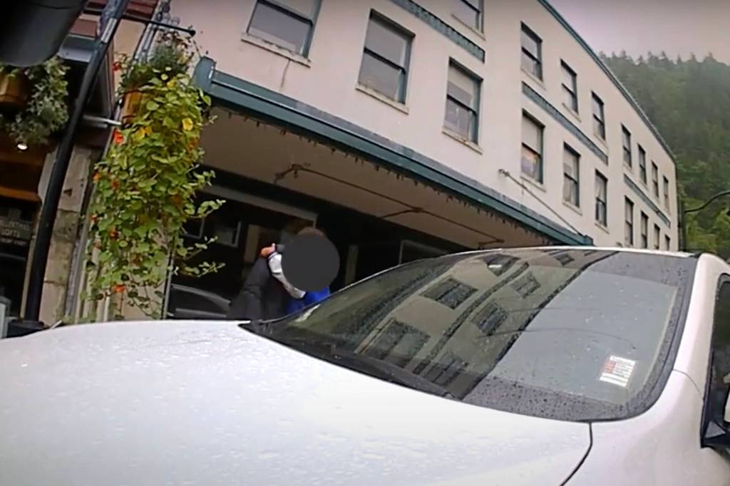 Steven Kissack is embraced by a friend about nine minutes into a confrontation with police on Front Street on July 15. (Screenshot from JPD bodycam video)