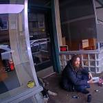 Steven Kissack, sitting in a covered entryway on Front Street, is approached by Juneau Police Department officer Lee Phelps at about 1:10 p.m. July 15. (Screenshot from Phelpss bodycam video)