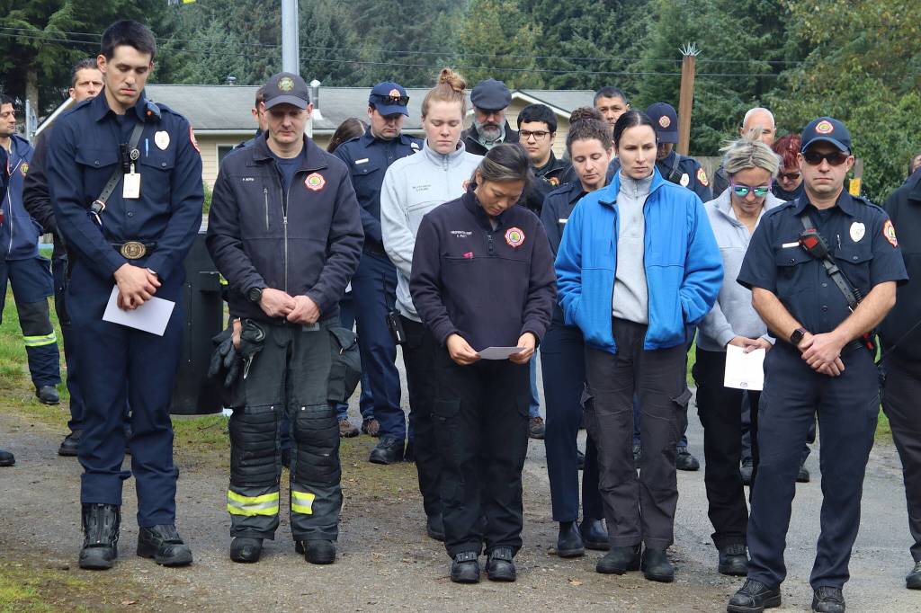 Juneau firefighters bow their heads for the invocation of a Sept. 11 commemoration ceremony Wednesday morning. (Mark Sabbatini / Juneau Empire)