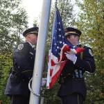 Detective Kirt Stage-Harvey (left) and Officer Aron Landry of the Juneau Police Department prepare to raise the flag to half mast at the September 11th Memorial at Riverside Rotary Park during a commemoration ceremony Wednesday morning. (Mark Sabbatini / Juneau Empire)