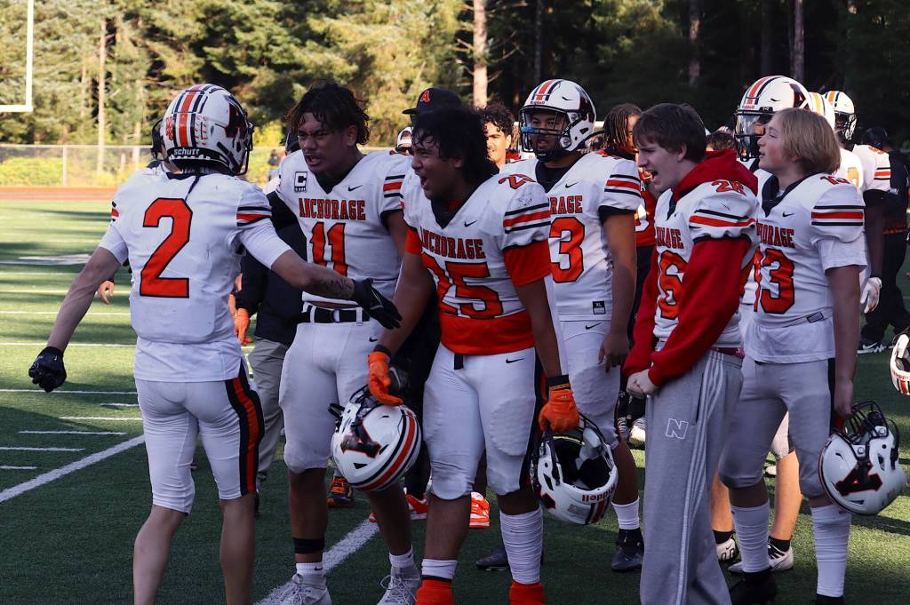 Ariel Sanchez (2) is congratulated by West Anchorage High School teammates after catching a Hail Mail touchdown pass at the end of the first half against Juneau-Douglas High School: Yadaa.at Kalé on Saturday at at Adair-Kennedy Memorial Park. (Mark Sabbatini / Juneau Empire)