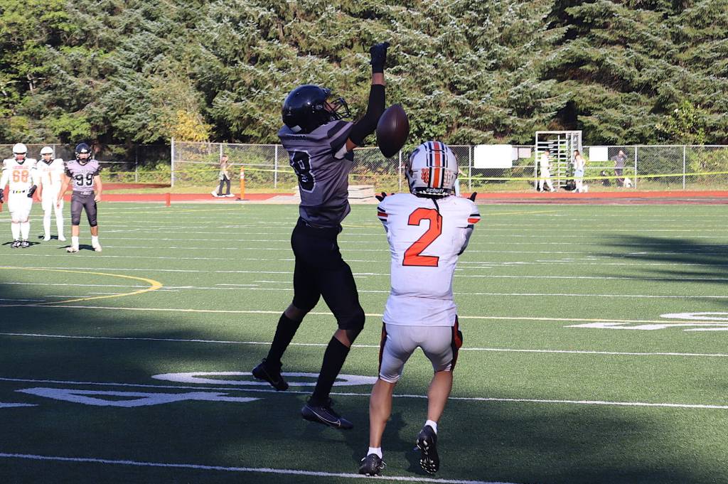 West Anchorage High Schools Ariel Sanchez (2) catches a Hail Mary pass beyond Juneau-Douglas High School: Yadaa.at Kalés Daniel Campbell and scores a touchdown to give the Eagles their first score at the end of the first half of Saturdays game at Adair-Kennedy Memorial Park. (Mark Sabbatini / Juneau Empire)