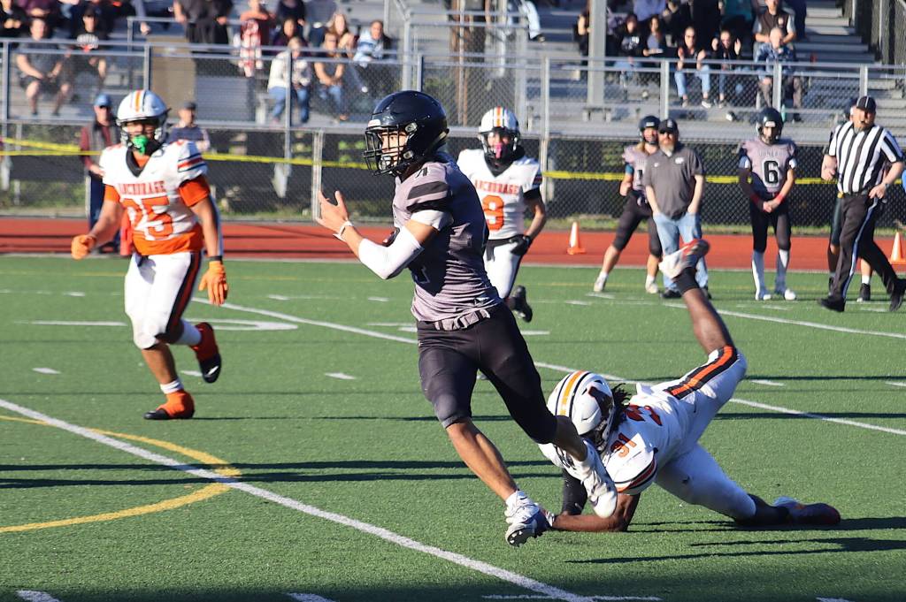 Juneau-Douglas High School: Yadaa.at Kalés Jayden Johnson (4) breaks free of a tackler as he runs a pass in for a touchdown against West Anchorage High School on Saturday at Adair-Kennedy Memorial Park. (Mark Sabbatini / Juneau Empire)