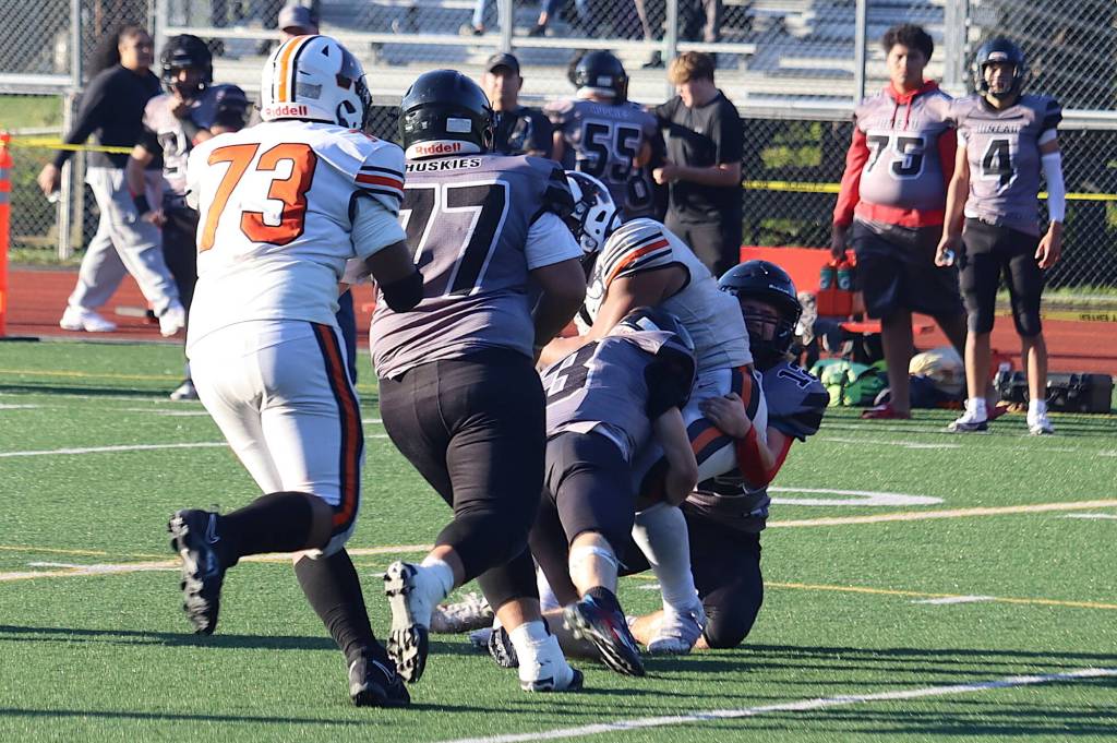A fourth-and-inches play by West Anchorage High School is stopped short of the first down by the Juneau Huskies Ethan Van Kirk (3) and Hyrum Fish (12) near the end of Saturdays game at Adair-Kennedy Memorial Park. (Mark Sabbatini / Juneau Empire)