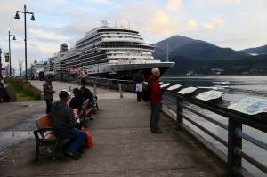 Cruise ship tourists watch floatplanes taxi out in Gastineau Channel on Monday. (Mark Sabbatini / Juneau Empire)