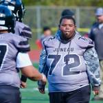 Juneau-Douglas High School: Yadaa.at Kalé freshman assistant coach and manager Jaasyah Crowley (72) directs varsity warmups before the Juneau Huskies’ game against West Anchorage High School last Saturday at Adair-Kennedy Memorial Park. (Klas Stolpe / For the Juneau Empire)