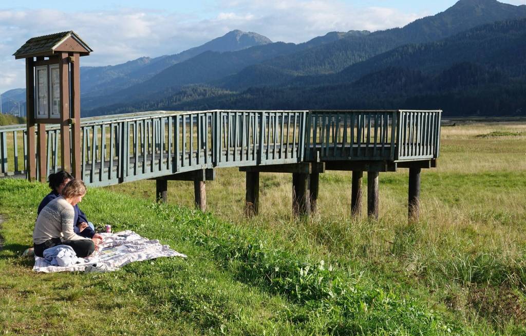 Sarah Dittman paints a watercolor scene of the wetlands as Ela Gonzalez watches. They are seated beside the Egan Drive pullout near the Rotary Club observation deck. (Laurie Craig / Juneau Empire)