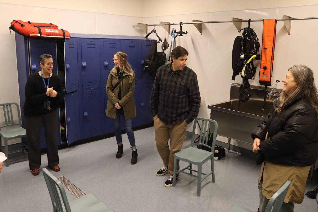 Visitor tour the wetsuit room at the new Áakʼw Tá Hít building at the University of Alaska Southeast on Friday. (Mark Sabbatini / Juneau Empire)