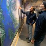 Vincent Colliard (left) and Børge Ousland examine a map of the Juneau Icefield at the Mendenhall Glacier Visitor Center on Friday night before giving a presentation about their planned crossing of the icefield. (Mark Sabbatini / Juneau Empire)