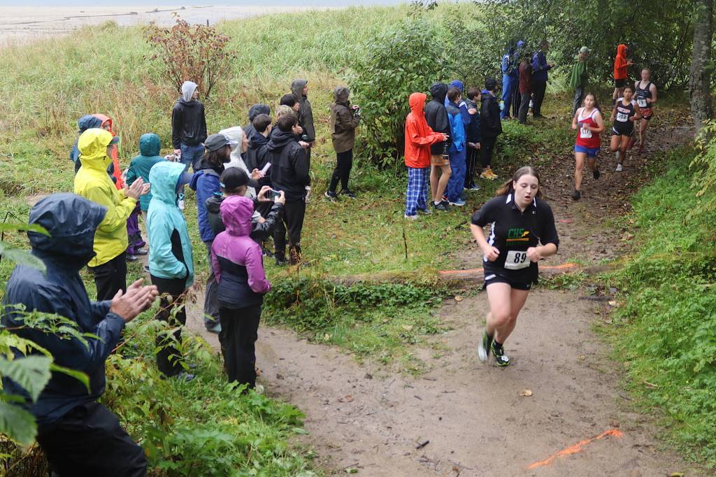 Girls get past a log across an uphill section of muddy trail during the Capital City Invite 5K race on Saturday. (Mark Sabbatini / Juneau Empire)