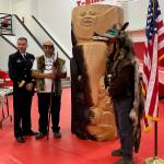 Rear Adm. Mark Sucato, Paul Aceveda and Ben Coronell stand beside Rob Mills totem pole base that was intentionally blackened by fire to represent the burning of Kake in 1869 during a ceremony on Saturday where the U.S. Navy apologized for the attack. (Laurie Craig / Juneau Empire)