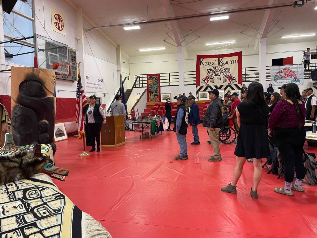 Kake residents and guests, including U.S. Navy personnel, stand for the national anthem during a ceremony Saturday where the Navy offered a formal apology for the bombardment of the village in 1869. (Laurie Craig / Juneau Empire)