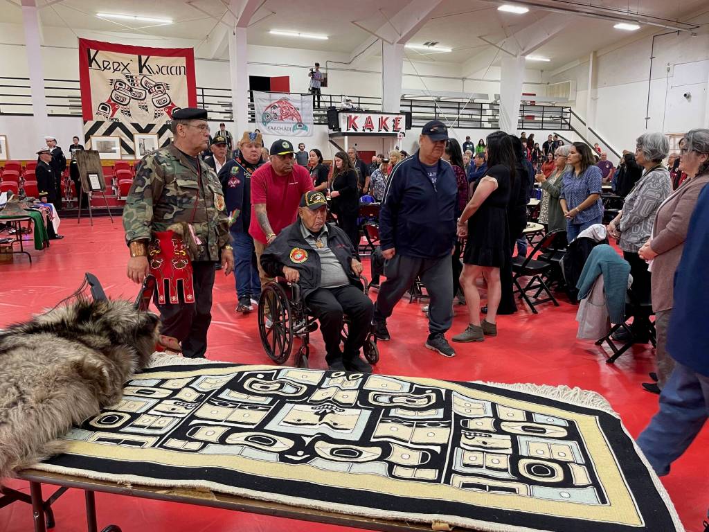 A color guard of Southeast Alaska Native veterans exits the front of Kakes community hall during a ceremony Saturday where the U.S. Navy formally apologized for the bombardment of the village in 1869. (Laurie Craig / Juneau Empire)