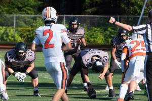Juneau Huskies junior quarterback Noah Ault (1) awaits the snap from junior center Jonah Mahle (54) as junior offensive lineman Kyle Carter (71) and junior running back Samuel Sarof (27) await action during a game against West Anchorage at Adair-Kennedy Memorial Park earlier this season. (Klas Stolpe / For the Juneau Empire)