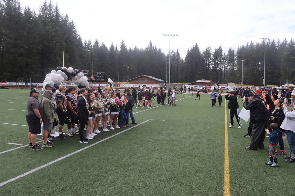 Seniors for Juneaus football and cheer teams pose for a group photo for coaches, family and friends before Saturdays game against Bartlett High School at Adair-Kennedy Memorial Park. (Mark Sabbatini / Juneau Empire)