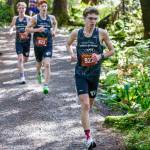 Juneau-Douglas High School: Yadaa.at Kalés Nick Iverson leads his teammates Erik Thompson and Owen Woodruff as they take first, second and third place in the Mens 5,000-meter race during the Division 1 Region V Cross Country meet at Ward Lake in Ketchikan on Saturday, Sept. 28, 2024. Iverson won the event with at time of 16:27.11. (Christopher Mullen/ Ketchikan Daily News)