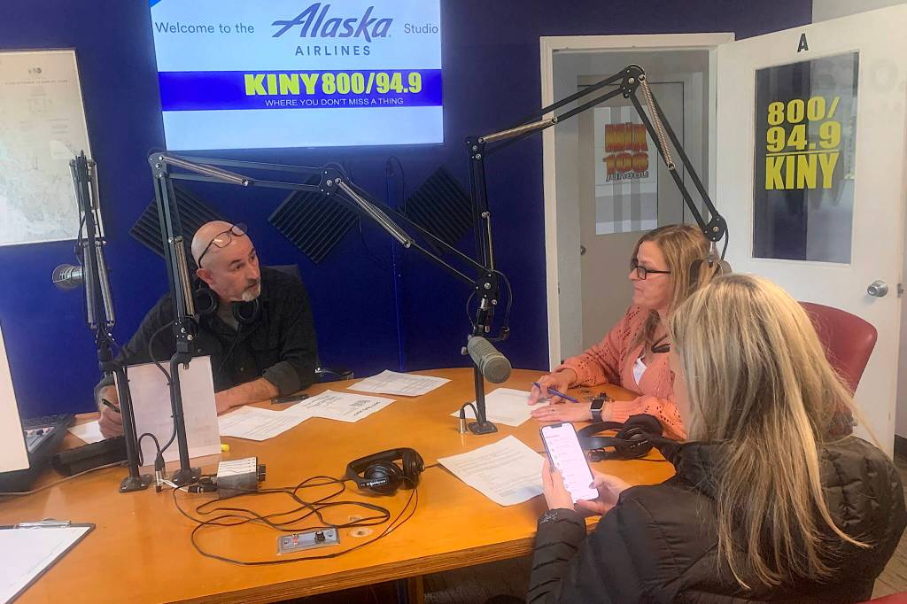 Mike Lane (left), talks to guests Brandi Billings (wearing pink) and Jessica Geary minutes before the first live broadcast in eight months of KINY-AMs Problem Corner on Monday. (Mark Sabbatini / Juneau Empire)