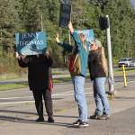 Jenny Thomas (center) and supporters wave signs for her Juneau Board of Education campaign at the McNugget Intersection on Sept. 19. Thomas, who is trailing in the race for one of three seats in an early vote count, is also one of the lead petitioners for an effort to recall two school board leaders. (Mark Sabbatini / Juneau Empire)